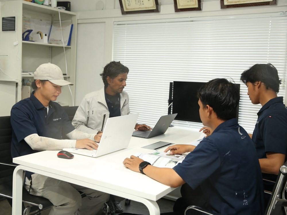 事務所で打ち合わせをするスタッフ